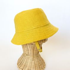 This yellow bucket hat is the perfect thing for babies toddlers and kids on sunny summer days! Washable linen and cotton fabirc makes it an easy go to for at the park, the beach, or even the backyard! This hat will protect delicate skin from the sun and will quickly become a favorite accessory! I made this sun hat from a bold yellow colored linen/cotton blend fabric. The strap closes with snaps under the chin keeps them from pulling it off. Brim measures approx. 2.25 inches. SIZES AVAILABLE 0-3 mos. - fits 14" to 16" head circumference 3-6 mos. - fits 15" to 17" head circumference 6-12 mos. - fits 16" to 18" head circumference 12-24 mos. - fits 17.5" to 19.5" head circumference Small (3 to 5 yrs) - fits 19" to 21" head circumference OVERVIEW + Sewn by me + Yellow Linen and Cotton blend Fab Cheap Yellow Cotton Bucket Hat, Summer Sun Hat With Uv Protection For Playtime, Uv Protection Sun Hat For Summer Playtime, Adjustable Solid Bucket Hat For Summer, Adjustable Cotton Bucket Hat For Beach Season, Adjustable Summer Bucket Hat For Playtime, Summer Play Brimmed Bucket Hat, Playful Cotton Bucket Hat With Short Brim, Adjustable Cotton Bucket Hat For Summer