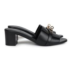 These Hermes Gigi 50 sandals are in Black calfskin leather with permabrass hardware, featuring a 2" heel, an iconic permabrass-plated Kelly buckle detail on front of sandal, natural leather soles, and are a size 37.5 EU. Origin: ItalyCondition: New and never worn (plastic on hardware)Accompanied by: Hermes box, dustbagsSize: 37.5 EU Evening Mules With Leather Sole And Low Heel, Elegant Mules With Single Toe Strap And Leather Sole, Luxury Formal Mules With Buckle Closure, Luxury Mules With Padded Heel And Single Toe Strap, Formal Calf Leather Mules With Buckle Closure, Evening Mules With Leather Sole And Single Toe Strap, Low Heel Sandals With Heel Strap For Galas, Formal Low Heel Luxury Mules, Formal Luxury Mules With Low Heel