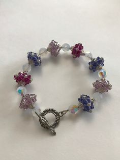 This bracelet is made with hand stitched beads, (fuchsia, white opal, tanzanite, and light amethyst) Swarovski Crystals, and silver colored findings. The hand stitched beads are made with Swarovski bicones and Toho seed beads. The bracelet measures at approximately 8 1/4 inches long. The clasp is a flower toggle clasp. If you have any questions or concerns feel free to contact owner and designer at hannahsjeweltique@gmail.com Purple Crystal Bracelet, Pineapple Bracelet, Cameo Bracelet, Jewelry Styles, Swarovski Crystal Bracelet, Light Amethyst, Purple Crystal, Styles Inspiration, Purple Crystals