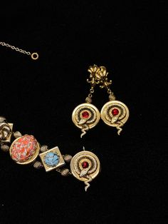 "Very little information can be found on the PIK MGK NYC jewelry makers but they did produce an exceptional art glass and serpent slide bracelet and earrings with this set; the dangle screw back earrings features the curled serpent and ruby red stone which matches one of the link on the bracelet and are 2\" long; the bracelet is 7\" long and 3/4\" wide with spring safety chain; each of the nine embossed links feature a different design and stone; the stone colors are amazing; ruby red, speckled Formal Metal Clip-on Jewelry, Vintage Round Clip-on Jewelry, Round Vintage Clip-on Jewelry, Fine Jewelry Bracelet With Cabochon, Costume Jewelry Round Matching Earrings, Costume Jewelry With Matching Round Earrings, Art Deco Jewelry With Matching Earrings, Costume Jewelry Matching Round Earrings, Round Costume Jewelry Matching Earrings