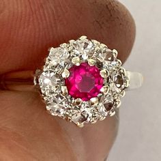 Beautiful vintage cluster ring with pink ruby and spinel, on a 9ct yellow gold shank, and platinum shoulders. This ring has a very vibrant pink centre stone which tests as ruby but may be a man-made ruby, and is surrounded by very sparkly white spinel. Condition: Excellent  Head size: 10mm x 10mm Finger size: Select from drop down menu. There is only one of these rings and it's existing size is N 1/2 ( US finger size 7) There is only one of these rings. This ring has a 9ct gold hallmark on it wi Classic Pink Cluster Ring With Prong Setting, Classic Ruby Ring With Rose Cut Diamond Cluster, Pink Round Cluster Ring With Halo Setting, Pink Round Cluster Ring With Prong Setting, Cluster Ruby Ring With Rose Cut Diamonds, Classic Ruby Cluster Ring With Center Stone, Red Diamond Cluster Ring With Halo Setting, Classic Cluster Ruby Ring With Center Stone, Cluster Ruby Diamond Ring With Center Stone