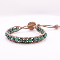 This single wrap leather bracelet is adjustable and has a second loop allowing some extra length. Size: Adjustable from ~6.5-7in         >First Loop at ~6.5inches         >Second Loop at ~7inches Beads: 6mm Stone Beads         >Green/Pink   Clasp: Coconut Button          >Brown Leather: Round Leather Cord         >Brown Thread: Upholstery Thread          >Brown *Photos are taken with care to ensure the color is portrayed correctly. However, due to different screen resolution, screen brightness, lighting, etc... from phone screens to computer screens, colors in the bracelet may differ slightly than pictured. If you have any questions, please don't hesitate to message me. Trendy Adjustable Hand-strung Wrap Bracelet, Adjustable Hand Wrapped Leather Wrap Bracelet, Adjustable Hand Wrapped Leather Bracelet With Round Beads, Adjustable Green Wrap Bracelet With Round Beads, Adjustable Hand-wrapped Beaded Leather Bracelet, Spiritual Adjustable Hand Wrapped Bracelet, Casual Beaded Leather Bracelet As A Gift, Adjustable Green Spiritual Wrap Bracelet, Adjustable Leather Beaded Bracelets With Round Beads