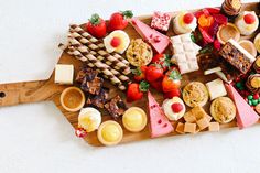 a wooden cutting board topped with lots of different types of food