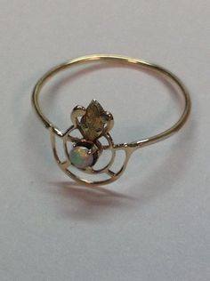 "This is a beautiful opal ring made from a converted stickpin from the Art Nouveau Era. The ring is 10k gold, tested but not marked , Rosey yellow gold and a green gold leaf. The ring has a firey 2 1/2mm prong set opal. It measures 3/8\" across the top. It weighs .4 grams and is a ring size 6 1/4, which could be sized for an additional fee. If you love dainty, this is for you. Any questions, please email me." Gold Ethiopian Opal Heirloom Rings, Oval Gold Opal Ring In 14k Gold, Heirloom Ethiopian Opal Gold Rings, Antique Opal Jewelry In Yellow Gold, Gold Opal Ring In 14k, Unique Gold Opal Ring In 14k, Gold Ethiopian Opal Ring Hallmarked, 14k Yellow Gold Opal Ring Birthstone, Heirloom Opal Ring In 14k Gold