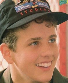 a boy wearing a hat and smiling for the camera