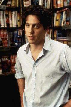 a man standing in front of a bookshelf