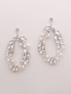 two pairs of earrings with pearls and crystal stones on the bottom, one in white