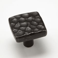 a black square shaped object sitting on top of a white surface with lots of dots