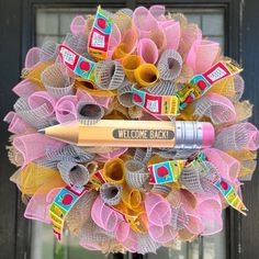 a welcome wreath with a pencil on it and some burlocks around the front door