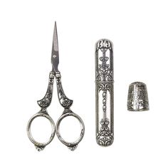 a pair of scissors and a thimble are next to each other on a white background