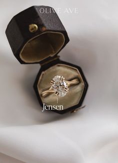 an open ring box with a diamond in it