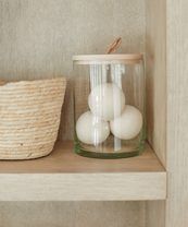 three white eggs in a glass jar on a shelf