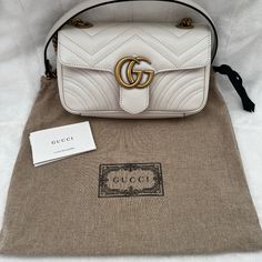 Newly Purchased. Worn Once. Great Condition. No Imperfections To Mention. The Small Gg Marmont Chain Shoulder Bag Has A Softly Structured Shape And An Oversized Flap Closure With Double G Hardware. The Sliding Chain Strap Can Be Worn Multiple Ways, Changing Between A Shoulder And A Top Handle Bag. Made In Matelass Chevron Leather With A Heart On The Back. White Matelass Chevron Leather With A Heart Antique Gold-Toned Hardware Made In Italy Double G Interior Zipper Pocket Sliding Chain Strap Can White Gucci Shoulder Bag With Detachable Strap, White Leather Gucci Shoulder Bag, Gucci Cream Rectangular Shoulder Bag, Gucci Cream Leather Shoulder Bag, White Gucci Shoulder Bag For Evening, Gucci Cream Crossbody Shoulder Bag, Gucci White Shoulder Bag For Everyday Use, High-end White Shoulder Bag With Gold-tone Hardware, White Gucci Shoulder Bag For Everyday Use