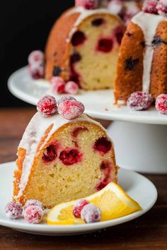 a bundt cake with white icing and cranberries is on a plate