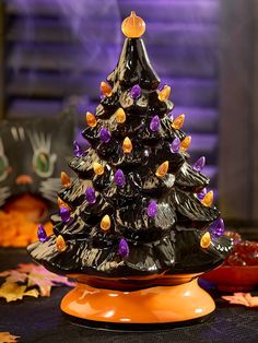 a black ceramic christmas tree sitting on top of an orange plate