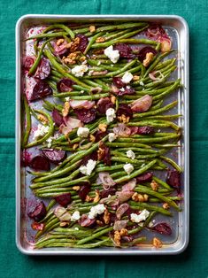 green beans, red onions and goat cheese on a platter with walnuts for garnish