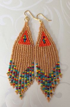 Handmade beaded long beige and multicolored seed bead earrings. Stunning handmade beaded earrings made with beige, orange and super bright multicolored 11/0 seed beads. The earrings have long flowing multicolored fringe. The french hook earwires and findings are sterling silver. These gorgeous Cheyenne style earrings are super long and brush your shoulders ever so slightly. Great for daywear and stunningly beautiful for the night out. Earrings measure approximately 4.5 inches including ear wires Colorful Beaded Brown Earrings For Beach, Brown Beaded Earrings For The Beach, Beach Beaded Earrings With Colorful Beads, Traditional Multicolor Beaded Earrings With Gold Beads, Traditional Brown Beaded Earrings With Tiny Beads, Bohemian Beaded Necklaces With Colorful Beads In Beige, Beige Bohemian Earrings With Colorful Beads, Multicolor Dangle Beaded Earrings With Gold Beads, Beige Beaded Earrings For The Beach