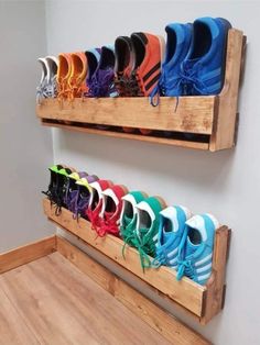 there are many pairs of shoes hanging on the wall in this shoe storage rack that is made out of pallets