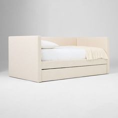 a bed that is made up with white sheets