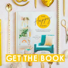 the happy home book is displayed with gold accessories and other items on top of it