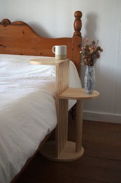 a bed with a wooden headboard and side table on top of it next to a vase