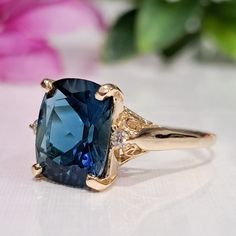 5.60 Carat Natural London Blue Topaz & Diamonds 14k Solid Gold Ring  Ring Material: 14k Solid Gold  Total Metal Weight: 3.8 Grams  Gemstone: Natural London Blue Topaz Gemstone Color: Dark Blue  Gemstone Shape: Cushion Gemstone Dimensions: 12.00x10.00 mm Gemstone Carat Weight: 5.52 Carat Gemstone Quantity: 1 Natural Round Shaped Diamonds Diamonds Quantity: 2 Diamonds Total Carat Weight: 0.08 Carat Total Carat Weight: 5.60 Carat Ring Quantity: One  Condition: New Delivered in an elegant gift box M Blue Diamond Ring With Gemstone Accents, Blue Cushion Cut Diamond Ring For Formal Occasions, Elegant Blue Sapphire Ring In 14k Gold, Formal Blue Cushion Cut Diamond Ring, Luxury Blue Birthstone Ring For Wedding, Blue Topaz Ring With Prong Setting In 14k Gold, 14k Gold Blue Sapphire Ring With Center Stone, Blue Birthstone Ring With Center Stone In 14k Gold, Classic Blue Sapphire Ring With Gemstone Accents