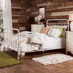 a white bed sitting in a bedroom next to a wooden wall