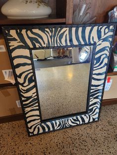 a zebra print mirror sitting on top of a counter