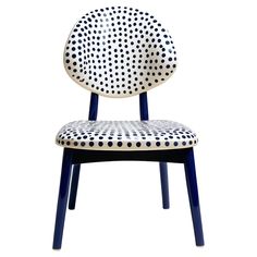 a white and blue chair with polka dots on the back, sitting in front of a white background