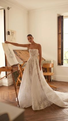 a woman standing in front of an easel