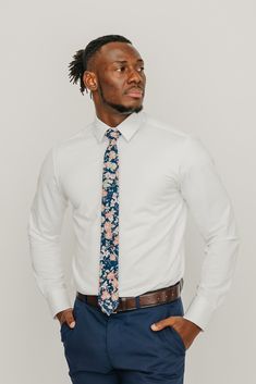 We pride ourselves in offering our customers some of the best skinny ties money can buy. Each DAZI tie is handmade from high quality imported fabrics. Features: Approx. 2.5" wide at the tip Approx. 58" in length 100% Cotton Background color: Navy. In some pictures it may appear faded black, but it is navy. Don't forget a matching pocket square! Shop our ﻿Lotus Pocket Square. Double Windsor, Cotton Background, Groom Ties, Boys Ties, Cool Ties, Solid & Striped, White Shirt Dress, Tall Guys, Navy Floral