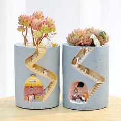 two planters with plants in them sitting on a table