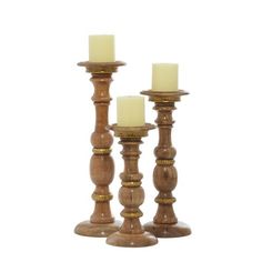 three wooden candlesticks with one candle lit