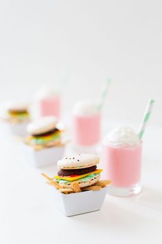 mini hamburgers and french fries are served in small containers with milkshakes on the side