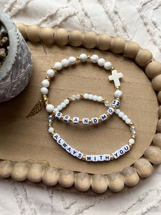 two bracelets with words on them sitting next to a potted plant in a vase