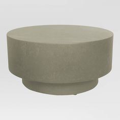 a round concrete table sitting on top of a white floor