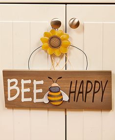 a wooden sign that says bee happy with a sunflower in the center on it