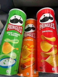 three cans of pringles are sitting next to each other on a car seat