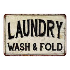 an old metal sign that says laundry wash and fold on the front, with black lettering