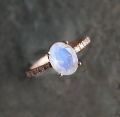 a close up of a ring with a stone in the middle and diamonds around it