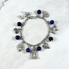 a bracelet with charms on it sitting on top of a snow covered ground and white background