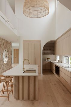 a kitchen with an island, sink and stools next to a counter top in the middle