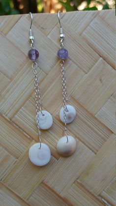 Operculum (cats eyes) shells combined with genuine amethyst gemstone bead hung from sterling silver chain to create a beautiful pair of earrings. We hand collect all our seaglass and shells in or off the waters of Maui. This unique pair of earrings measures 3 1/2 inches from the top of the earwire to the bottom of the shell. They are very lightweight and fun to wear for any occasion. Earrings will come to you wrapped in tissue in an organza bag, ready to enjoy. A great gift for anyone and any age. We ship in a box by priority mail Handmade Silver Shell-shaped Earrings, Handmade Mother Of Pearl Shell-shaped Earrings, Silver Shell-shaped Pearl Earrings For Gifts, Adjustable Silver Shell-shaped Earrings, Silver Shell-shaped Earrings With Pearl Drop, Cats Eyes, Tahitian Pearl Necklace, Sterling Silver Choker, Choker Style Necklace