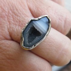 "Silver Mini Geode Ring Gray Druzy Ring Sparkly Druse Gemstone Ring: A stunning, one-of-a-kind, handmade stackable ring featuring a natural sparkling druzy geode set in sterling silver. The geode is gray and white and it measures 11/16\" by 7/16\". Band is 1/16\" wide. The ring itself is a size 6. Completely handmade by myself in sterling silver. Enter my shop: https://www.etsy.com/shop/artdi Join me on Facebook: https://www.facebook.com/Artdi-Diana-Anton-Jewelry-Design-44805607932/ Find me on I Artisan Rings With Natural Stones For Gift, Artisan Gemstone Promise Rings, Artisan Crystal Gemstone Ring, Artisan Open Ring With Natural Stones, Adjustable Stackable Rings With Natural Stones, Artisan Open Ring Gemstone Jewelry, Toe Ring With Natural Stones For Gift, Spiritual Open Ring With Natural Stones, Adjustable Natural Stone Rings For Anniversary