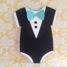 a paper cutout of a tuxedo and bow tie on a floral background