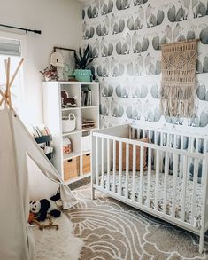 a baby's room with a crib and wallpaper