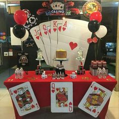 a casino themed table with cards and balloons