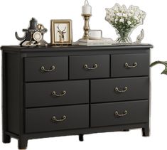 a black dresser with flowers and pictures on top