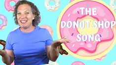 a woman holding up two doughnuts in front of a donut shop sign