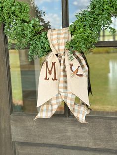 a door hanger with the letter m on it and a bow tied to it